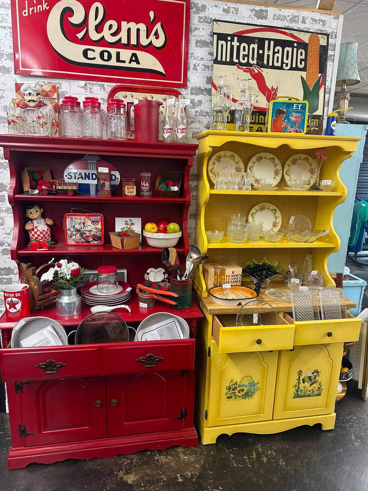 Red and yellow painted hutches under a Clem’s Cola sign